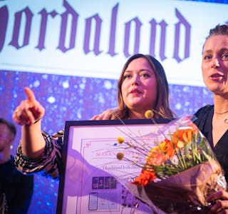 Kristina Sofie Kvåle og Camilla Skaar på scena under prisutdeling, med diplom og blomar i hendene.